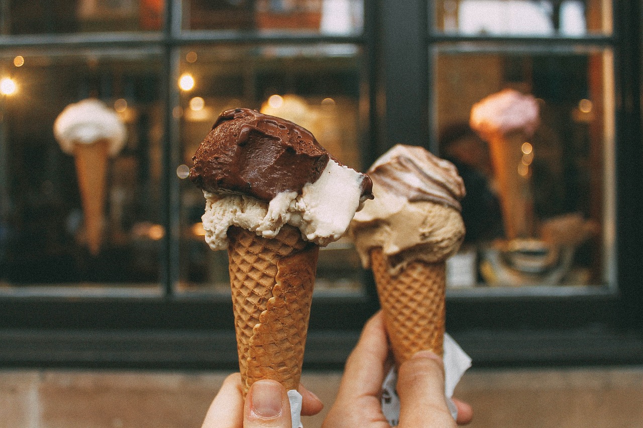 Two hands holding ice cream cones
